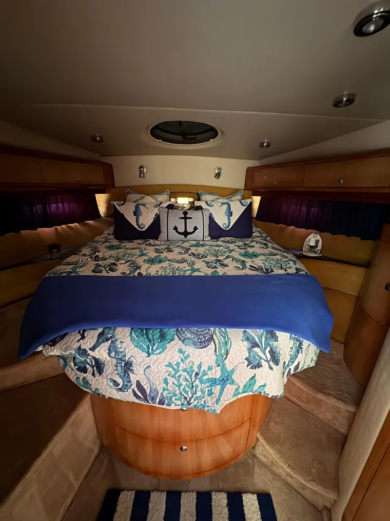 Slide: The Image of 2003 Regal 4260 Express Cruiser cabin with nautical-themed bedding and cozy interior. - 18
