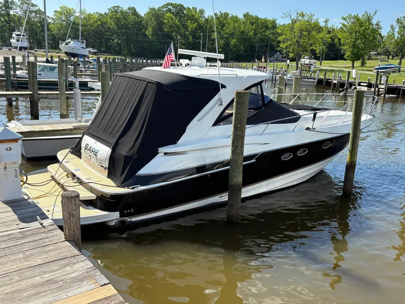 Slide: The Image of 2003 Regal 4260 Express Cruiser docked at a marina, featuring a sleek black and white design. - 2