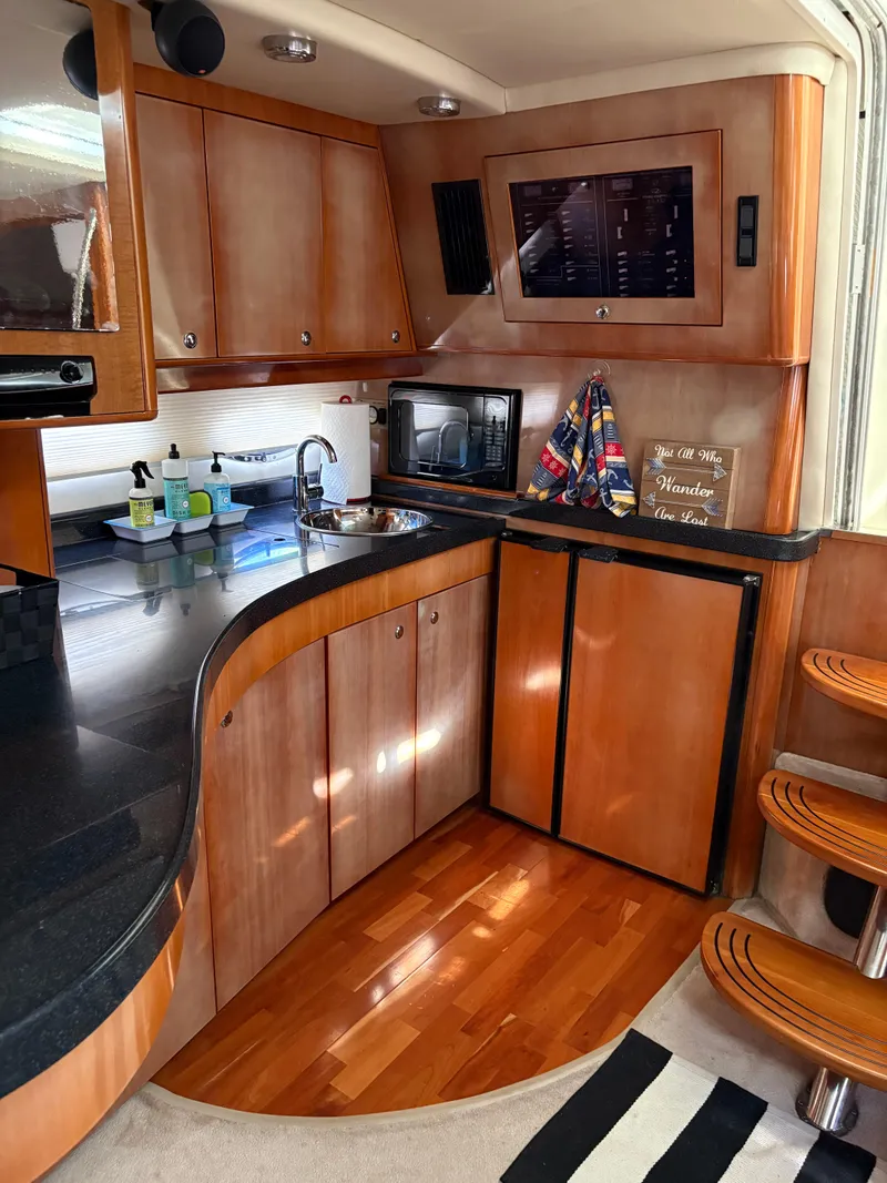 Slide: The Image of 2003 Regal 4260 Express Cruiser interior with wood cabinetry and modern kitchen amenities. - 23