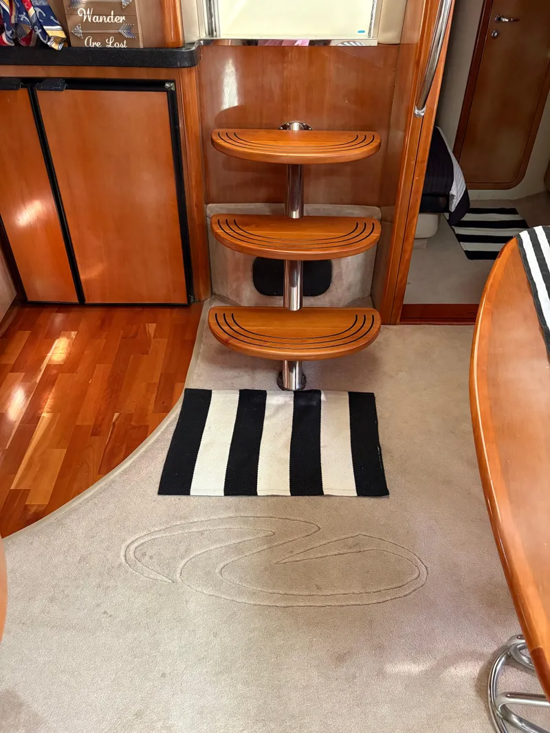 Slide: The Image of Interior of 2003 Regal 4260 Express Cruiser with wooden steps and striped rug. - 25