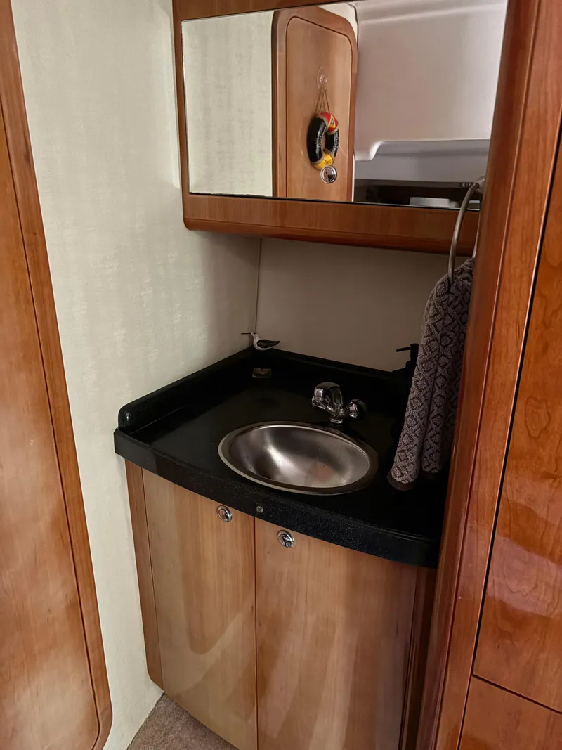 Slide: The Image of 2003 Regal 4260 Express Cruiser bathroom with wooden cabinetry and stainless steel sink. - 29