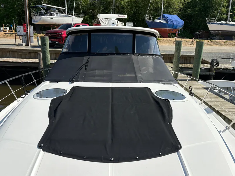 Slide: The Image of 2003 Regal 4260 Express Cruiser docked, featuring a black canvas cover. - 3