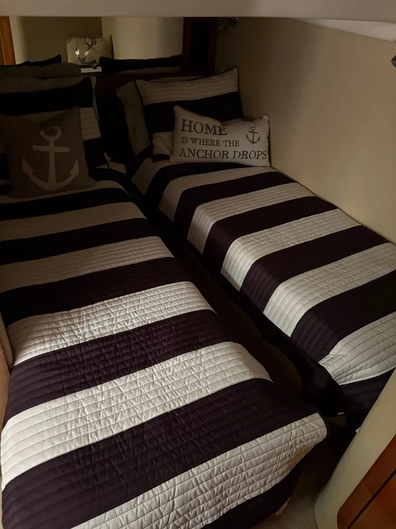 Slide: The Image of Twin beds with striped bedding in a 2003 Regal 4260 Express Cruiser cabin. - 30