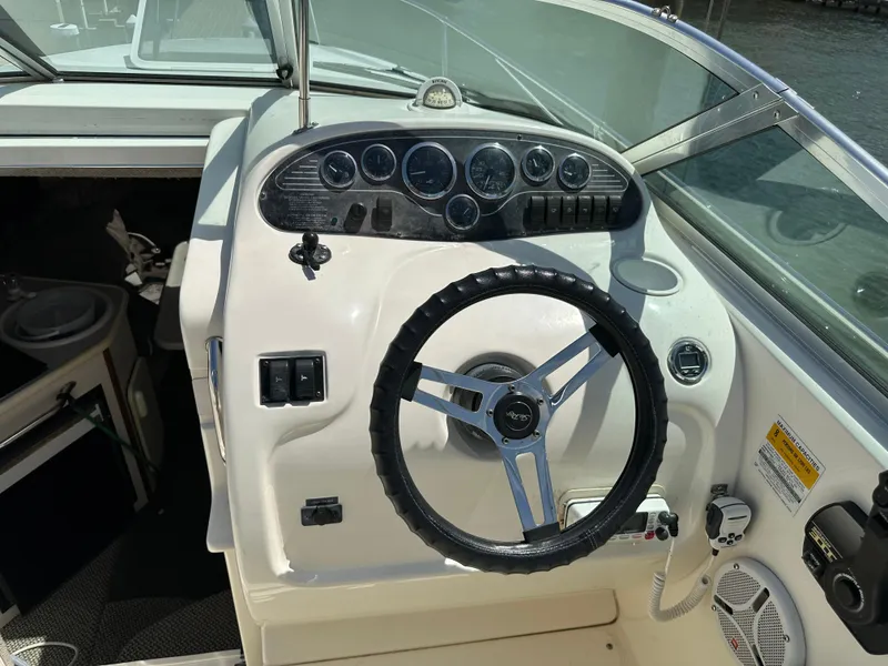 Slide: The Image of 1998 Sea Ray 240 Sundancer boat dashboard with steering wheel and instrument panel. - 10