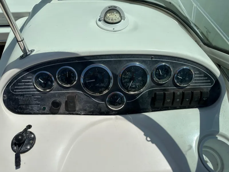 Slide: The Image of Dashboard of a 1998 Sea Ray 240 Sundancer boat with gauges and compass. - 11
