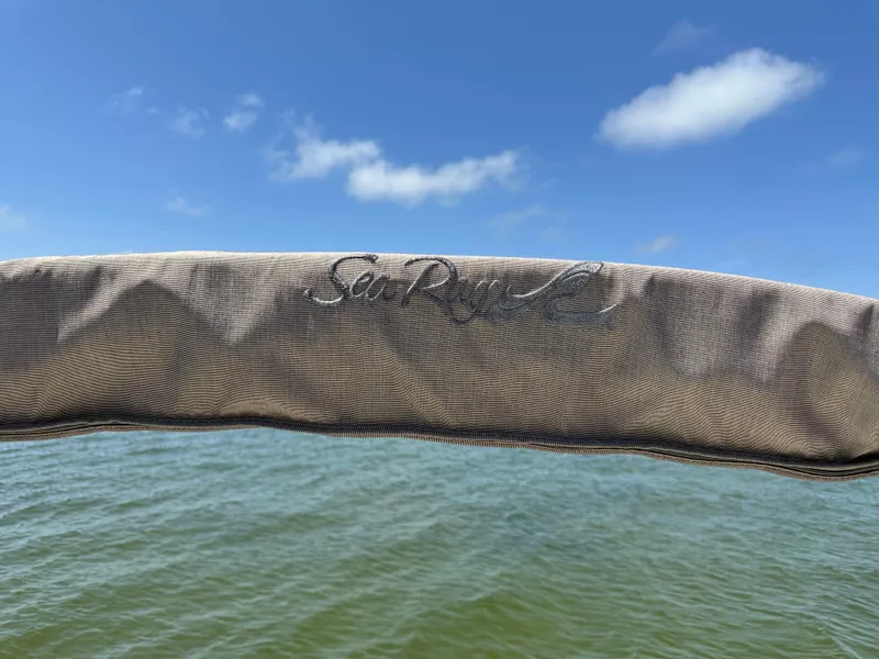 Slide: The Image of 1998 Sea Ray 240 Sundancer boat cover with logo, against a blue sky and water backdrop. - 19