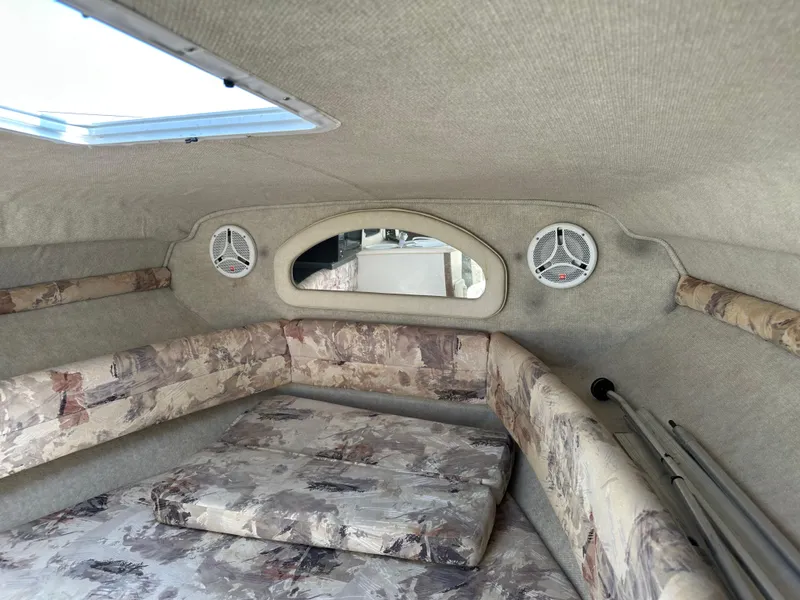Slide: The Image of 1998 Sea Ray 240 Sundancer cabin interior with patterned seating and overhead hatch. - 22