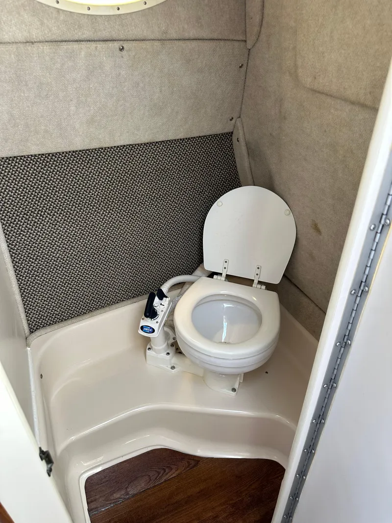 Slide: The Image of 1998 Sea Ray 240 Sundancer boat bathroom with compact marine toilet. - 29