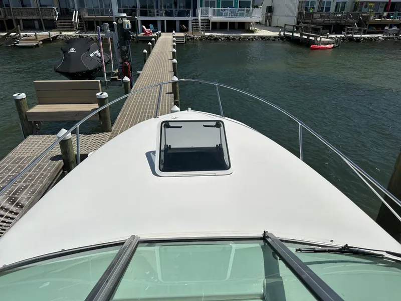 Slide: The Image of 1998 Sea Ray 240 Sundancer docked at marina, view from bow. - 3