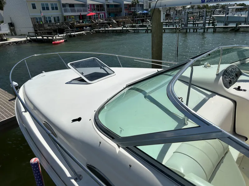 Slide: The Image of 1998 Sea Ray 240 Sundancer boat docked by waterfront homes. - 4