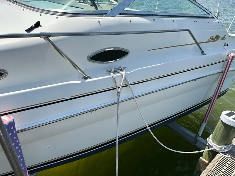 Slide: The Image of 1998 Sea Ray 240 Sundancer boat docked with rope, side view. - 6