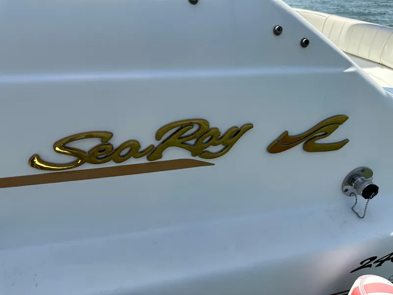 Slide: The Image of 1998 Sea Ray 240 Sundancer boat logo on white surface. - 7