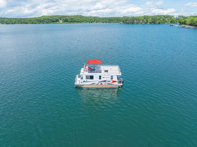 Slide: The Image of Houseboat on a serene lake, Twin Anchors 3010 model, 2016, with lush green shoreline. - 1