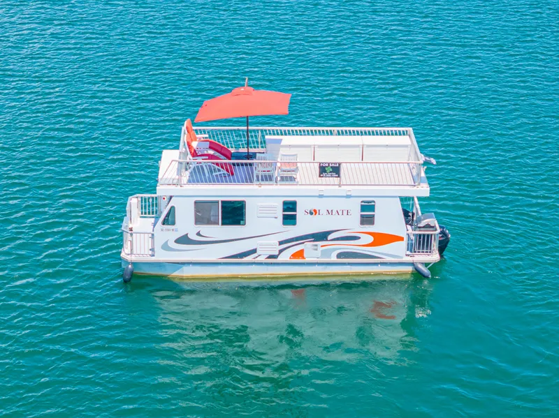 Slide: The Image of Houseboat on clear water, Twin Anchors 3010, 2016 model, with rooftop deck and umbrella. - 16