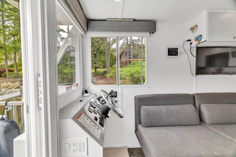 Slide: The Image of Interior of 2016 Twin Anchors 3010 houseboat with steering console and gray seating. - 25