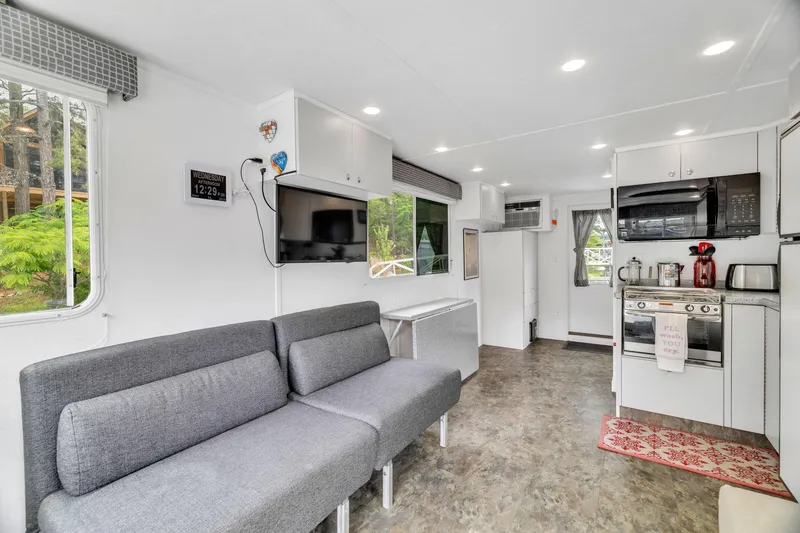 Slide: The Image of Modern 2016 Twin Anchors 3010 houseboat interior with sleek kitchen and cozy seating area. - 26