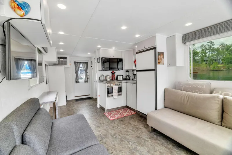 Slide: The Image of Interior of 2016 Twin Anchors 3010 houseboat with modern kitchen and cozy seating area. - 27