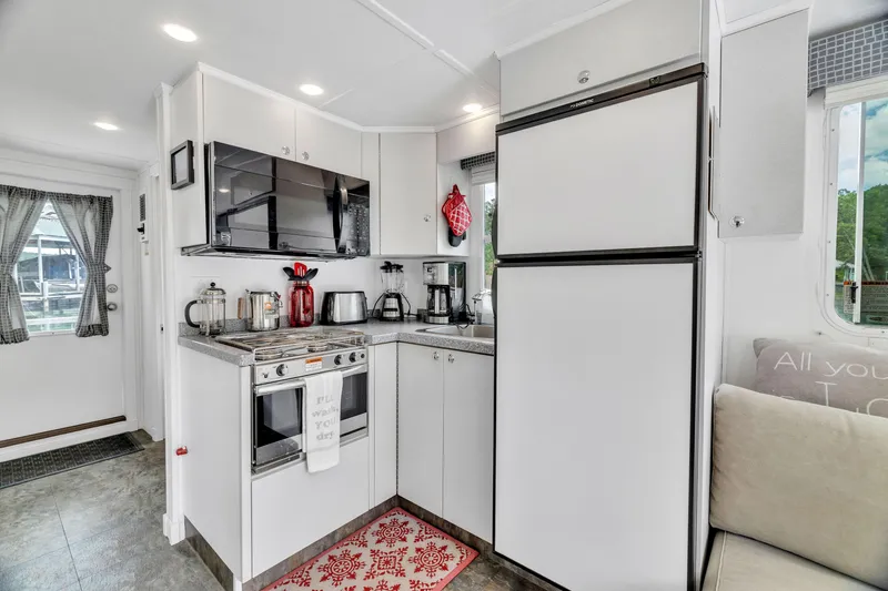 Slide: The Image of Modern kitchen in a 2016 Twin Anchors 3010 houseboat with appliances and cozy decor. - 28