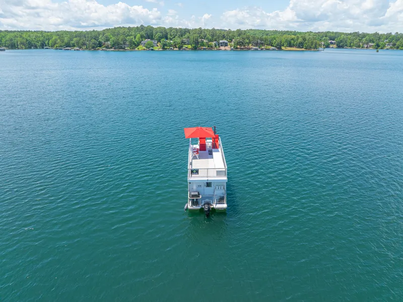 Slide: The Image of Houseboat on a serene lake, Twin Anchors 3010, 2016 model, with red canopy. - 3