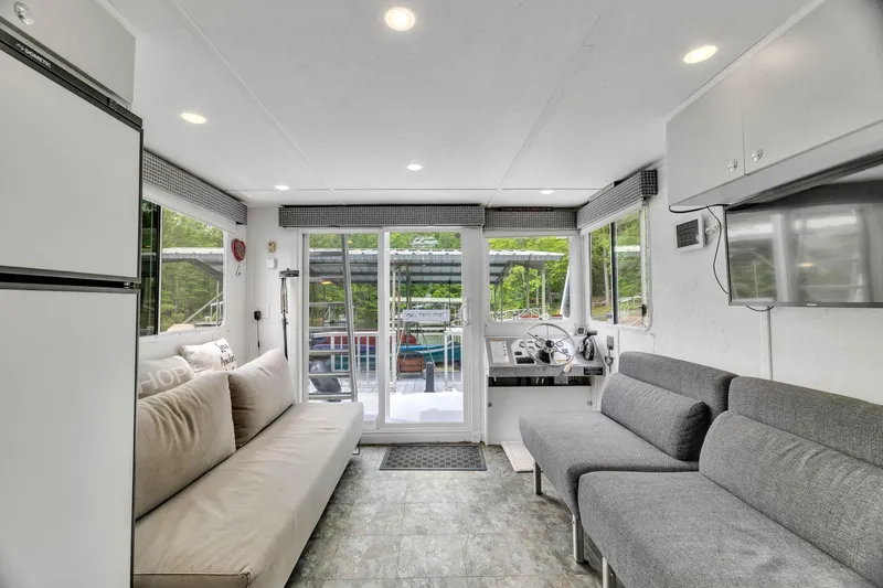 Slide: The Image of Interior of 2016 Twin Anchors 3010 houseboat with modern seating and large windows. - 32