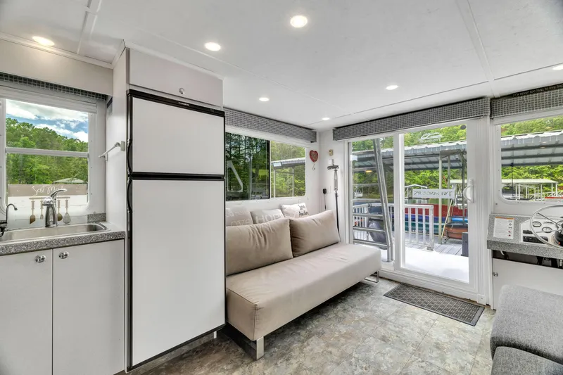 Slide: The Image of Modern interior of 2016 Twin Anchors 3010 houseboat with sofa, kitchen, and large windows. - 34