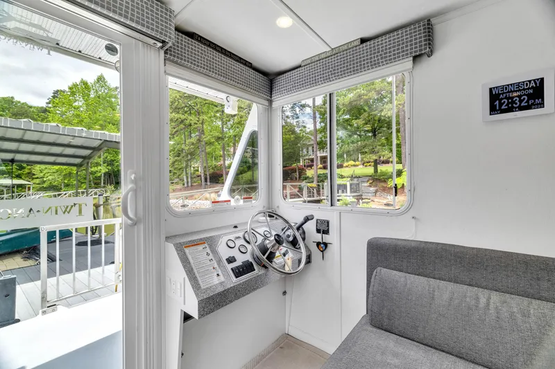 Slide: The Image of Interior of 2016 Twin Anchors 3010 boat with steering wheel and seating area. - 36