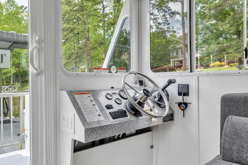 Slide: The Image of Steering console of a 2016 Twin Anchors 3010 houseboat, featuring controls and gauges. - 37