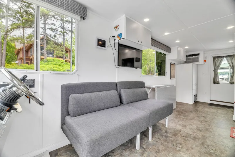 Slide: The Image of Modern interior of 2016 Twin Anchors 3010 houseboat with gray sofa and mounted TV. - 39