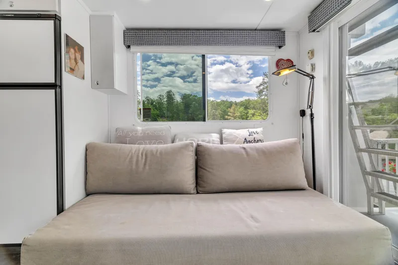 Slide: The Image of Interior of 2016 Twin Anchors 3010 houseboat with cozy seating and scenic window view. - 40