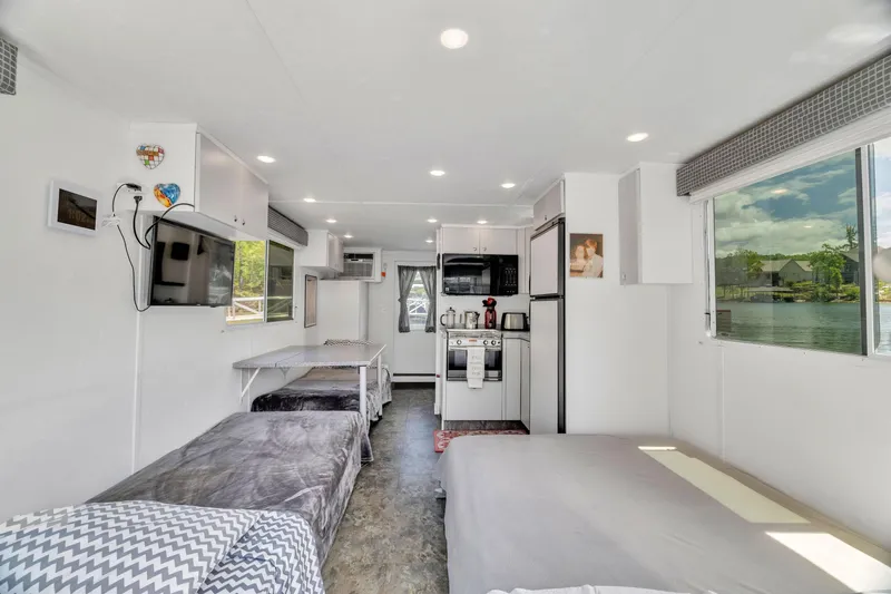 Slide: The Image of Interior of 2016 Twin Anchors 3010 houseboat with modern kitchen and cozy living area. - 41