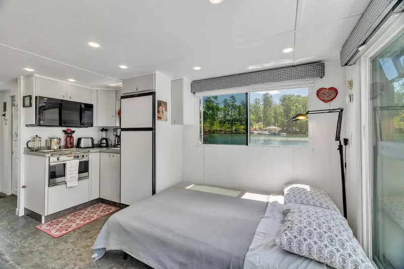 Slide: The Image of Cozy 2016 Twin Anchors 3010 houseboat interior with kitchen, bed, and scenic window view. - 42