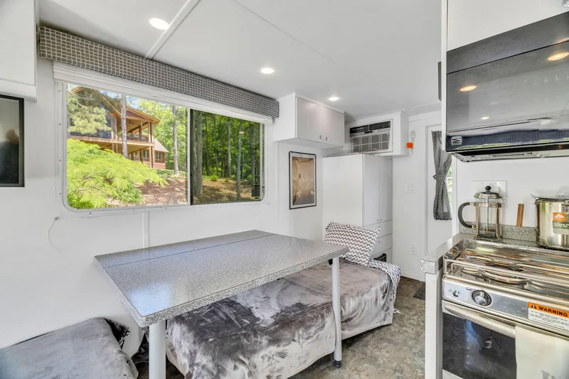 Slide: The Image of Modern 2016 Twin Anchors 3010 interior with dining area, kitchen, and large window view. - 43