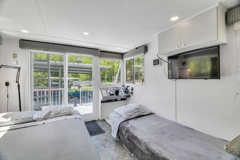 Slide: The Image of Interior of 2016 Twin Anchors 3010 houseboat with beds, TV, and large windows. - 45