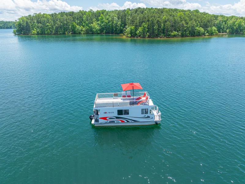 Slide: The Image of Houseboat on serene lake with lush forest backdrop, Twin Anchors 3010, 2016 model. - 5