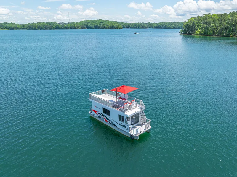 Slide: The Image of Houseboat on a serene lake, Twin Anchors 3010 model, 2016, with lush green shoreline. - 6