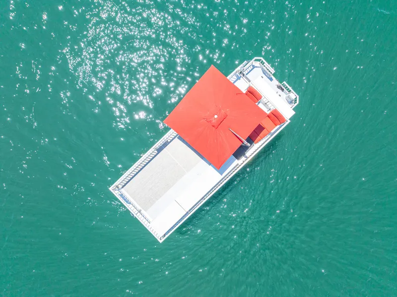 Slide: The Image of Aerial view of 2016 Twin Anchors 3010 houseboat with red roof on turquoise water. - 9