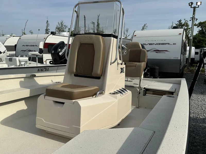 Slide: The Image of 2025 Xpress Hyper-Lift Series H22B boat with beige seating, parked near RVs. - 8