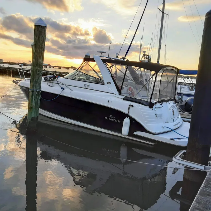 The Image of 2007 Rinker 300 Express Cruiser docked at sunset, reflecting on calm water. - 0