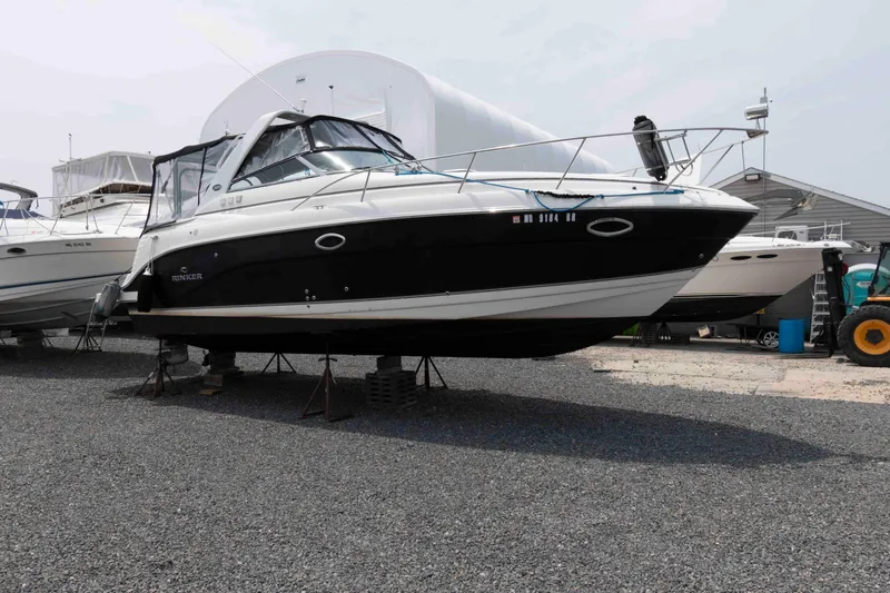 Slide: The Image of 2007 Rinker 300 Express Cruiser on dry dock, black and white hull, side view. - 1