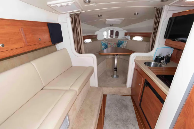 Slide: The Image of 2007 Rinker 300 Express Cruiser interior with seating, kitchenette, and dining area. - 11