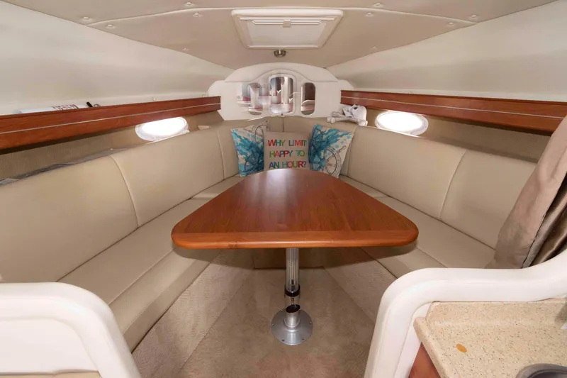 Slide: The Image of 2007 Rinker 300 Express Cruiser interior with beige seating and wooden table. - 12