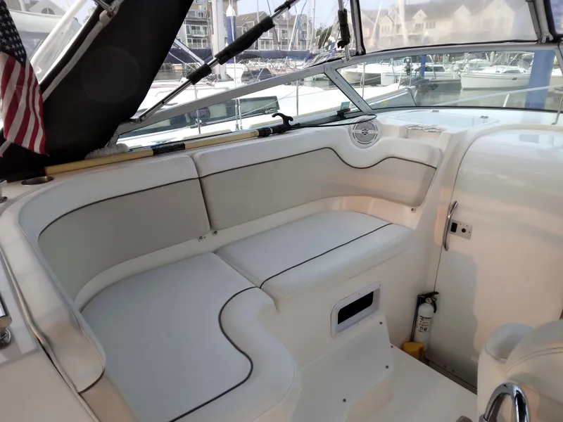 Slide: The Image of 2007 Rinker 300 Express Cruiser interior with white seating and marina view. - 6