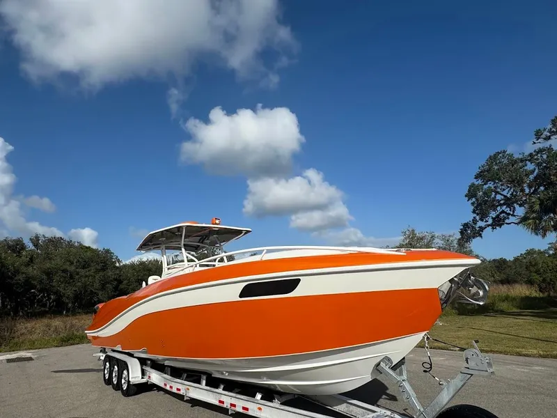 Slide: The Image of 2015 Deep Impact 399 Cabin boat on trailer under clear blue sky. - 10