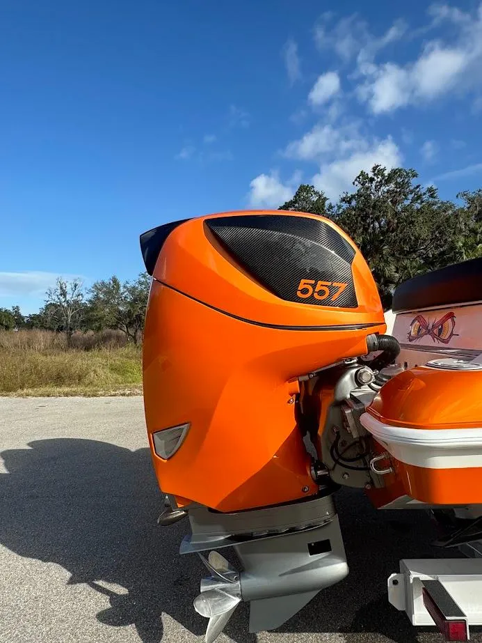 Slide: The Image of Orange outboard motor on a 2015 Deep Impact 399 Cabin boat under a clear blue sky. - 17