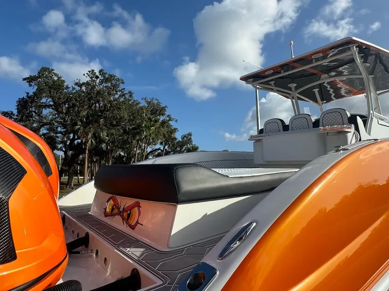 Slide: The Image of 2015 Deep Impact 399 Cabin boat with orange accents under a blue sky. - 19