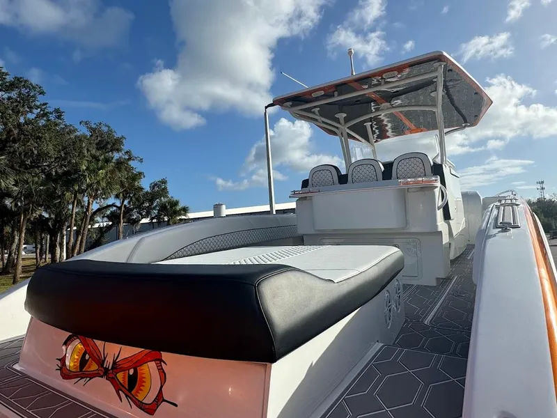Slide: The Image of 2015 Deep Impact 399 Cabin boat with custom seating and vibrant design under a clear sky. - 20