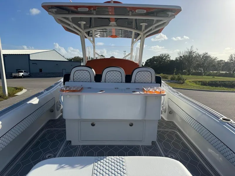 Slide: The Image of 2015 Deep Impact 399 Cabin boat interior with seating and storage, under a clear blue sky. - 36