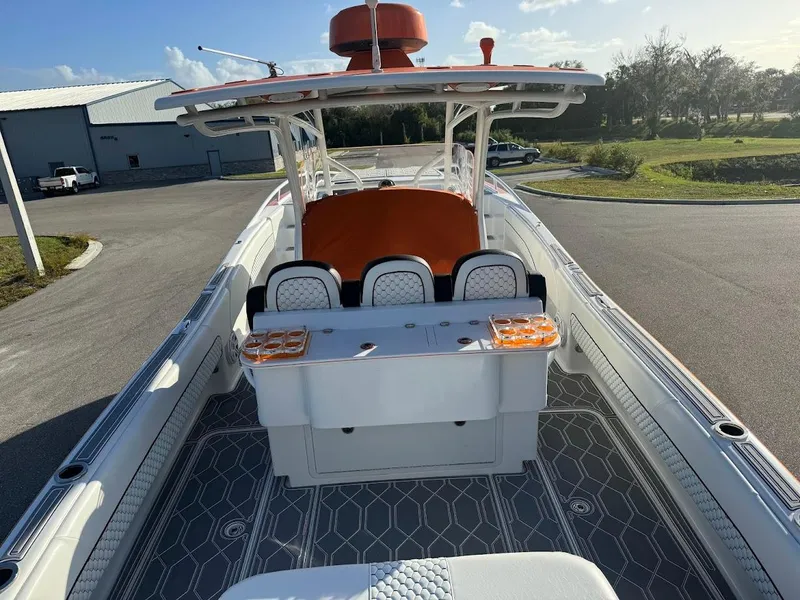 Slide: The Image of 2015 Deep Impact 399 Cabin boat with orange accents, docked in a sunny marina. - 37