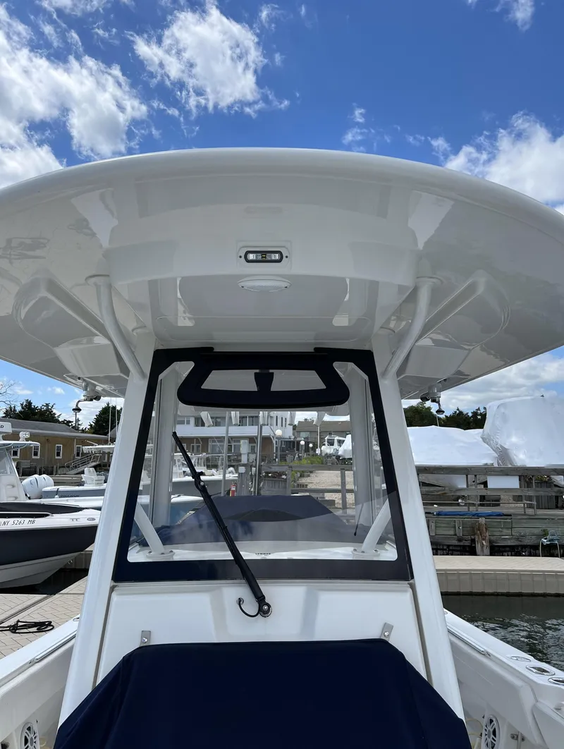 Slide: The Image of 2022 Regulator 31 boat at marina, featuring sleek design and modern canopy. - 2