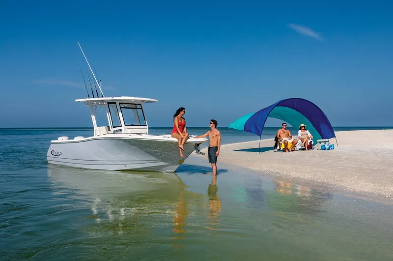 Slide: The Image of 2023 Robalo R270 boat near beach with people relaxing under a canopy. - 3